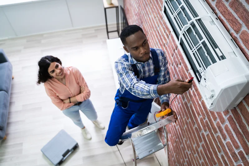 AC repair technician fixing ductless mini split wall unit