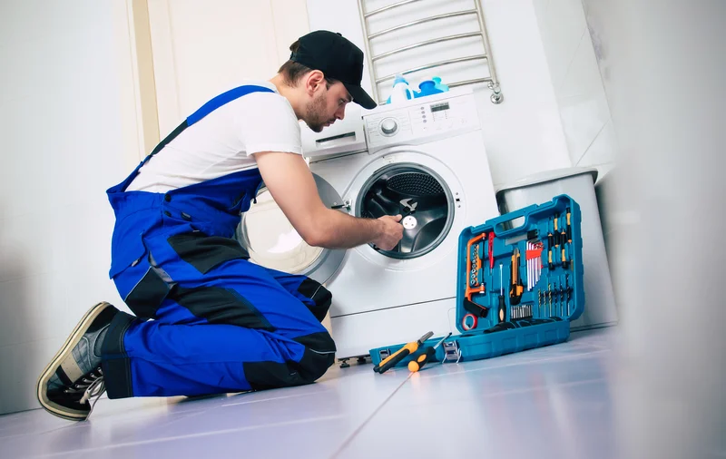 Professional washer repair service with tools and technician.